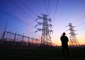 Silhouette of a construction worker and a pylon