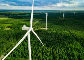 Aerial shot of wind turbines in green fields