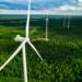Aerial shot of wind turbines in green fields