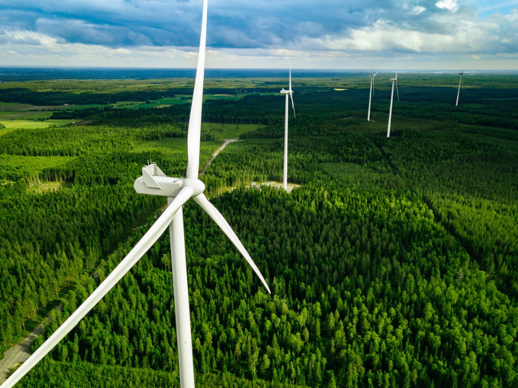 Aerial shot of wind turbines in green fields