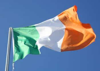 Irish flag blowing in the wind with a sky background