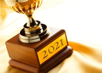 Trophy with engraved "2021" plaque, all against a yellow satin background