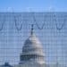 Photo of the U.S. Capitol building in the middle, with the blurry fence in the immediate foreground