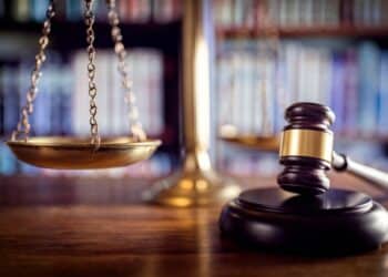 Gavel with scales in the background on a wooden desk