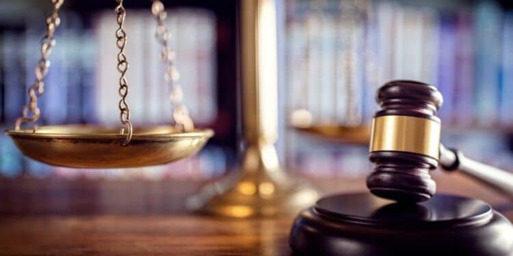 Gavel with scales in the background on a wooden desk
