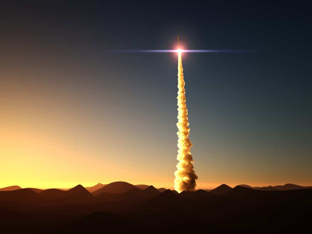 Stock photo of a rocket launching at sunrise in the desert.