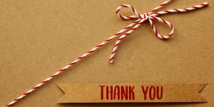 Brown label with "Thank you" in red letters with a red and white string with a bow, all on a brown background
