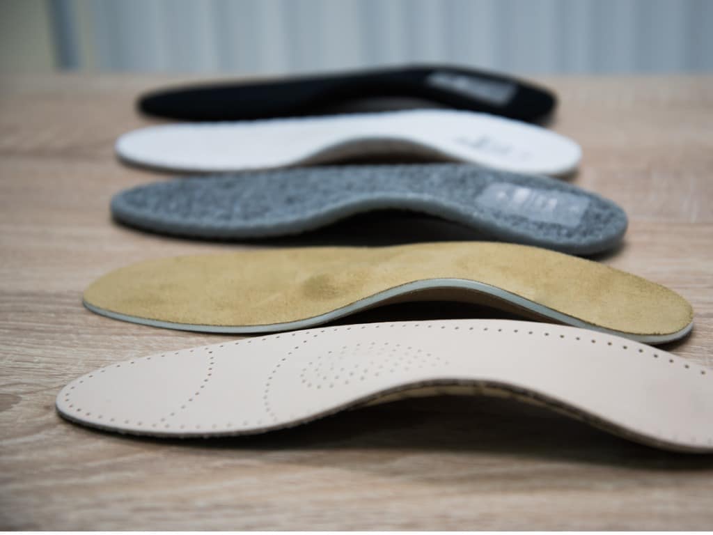 A variety of shoe inserts of different shapes and colors