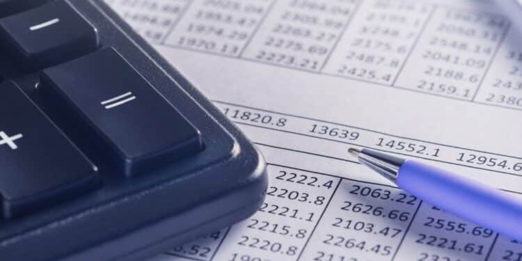 A calculator and pen sitting on top of financial documents