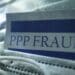 A document with the words "PPP Fraud" laying on a medical facemask.