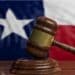 Photo of a gavel with the Texas flag in the background