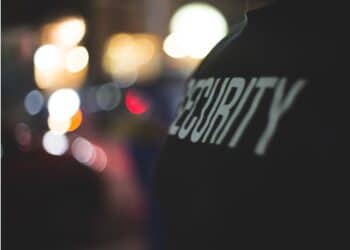 Back of a person wearing a security jacket.