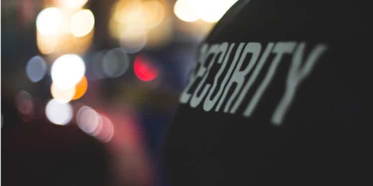 Back of a person wearing a security jacket.