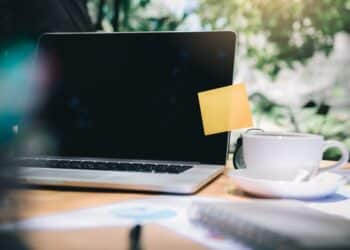 Photo of a laptop with a sticky note on the screen