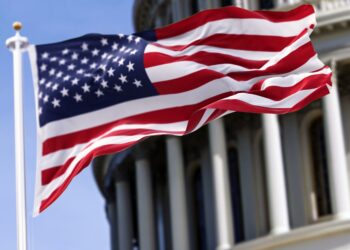 American flag in front of the U.S. Capitol building