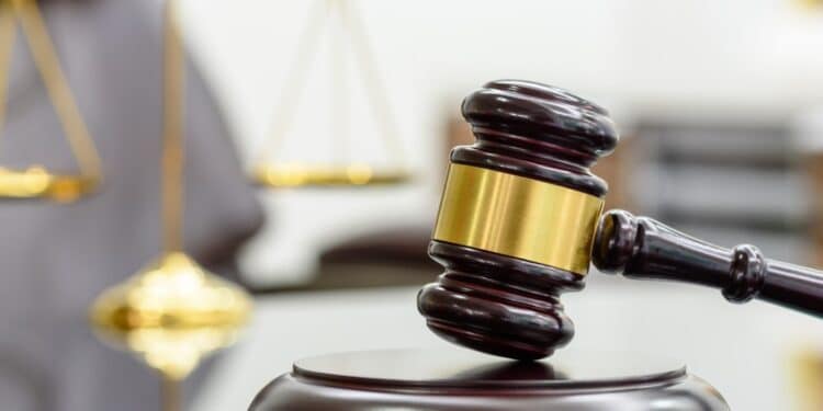 Photo of a gavel with a blurred scales of justice in the background