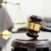 Photo of a gavel with a blurred scales of justice in the background