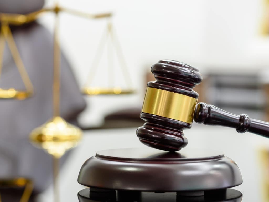 Photo of a gavel with a blurred scales of justice in the background