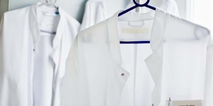 Two doctor's lab coats hanging up on clothes hangers