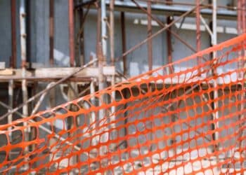 Orange construction net in the foreground and a building under construction in the background