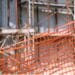 Orange construction net in the foreground and a building under construction in the background