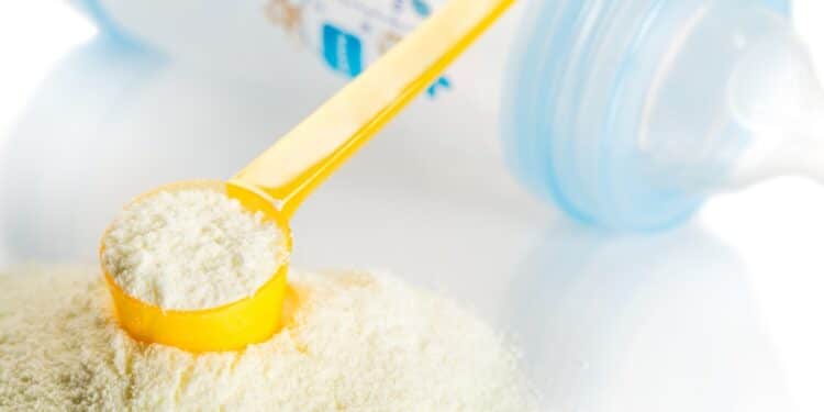 Baby formula with a yellow scoop and a baby bottle