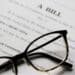 Stock image of glasses atop a bill waiting to be made law