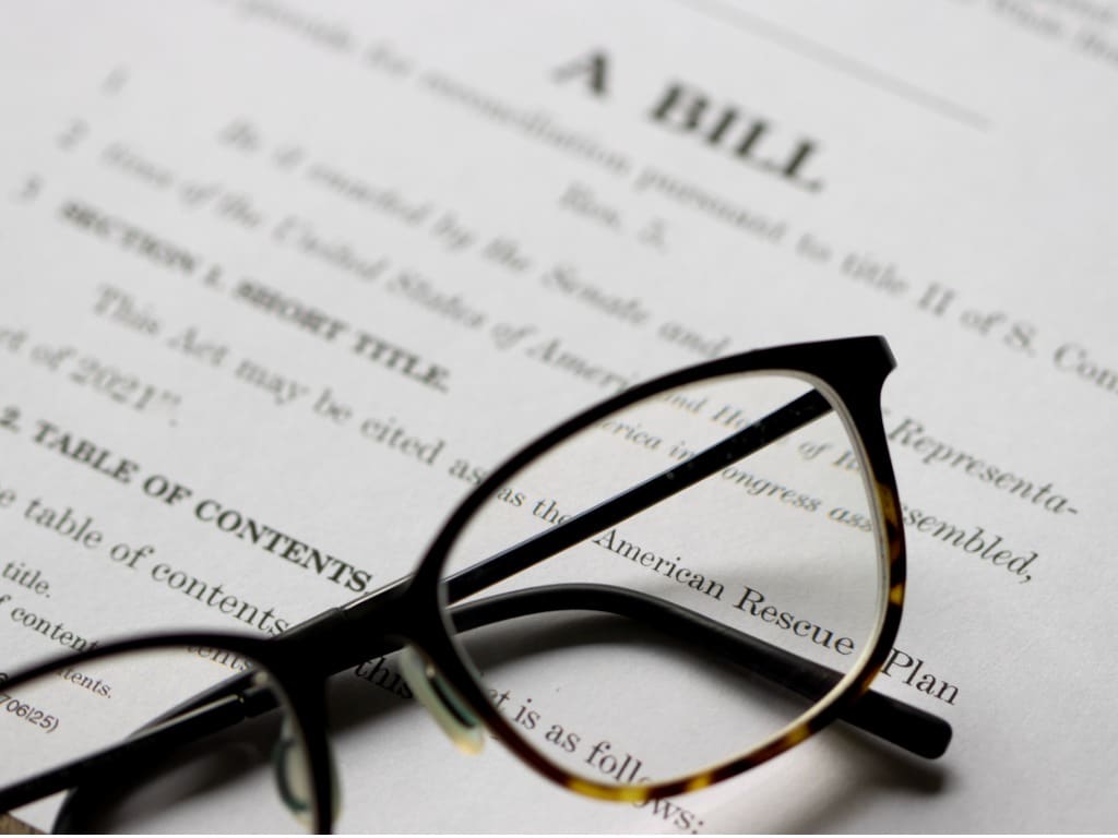Stock image of glasses atop a bill waiting to be made law