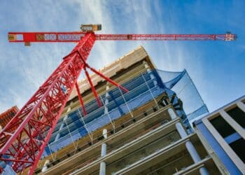 View of an orange crane and a building from a low angle