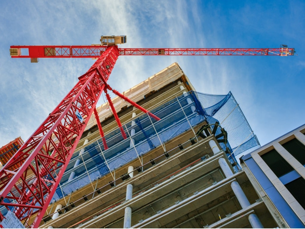 View of an orange crane and a building from a low angle