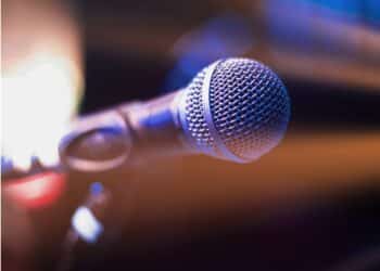 Close-up of a microphone against a dark stage background