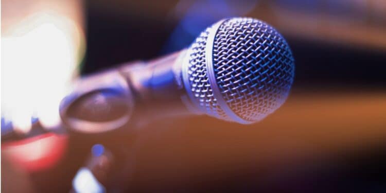 Close-up of a microphone against a dark stage background