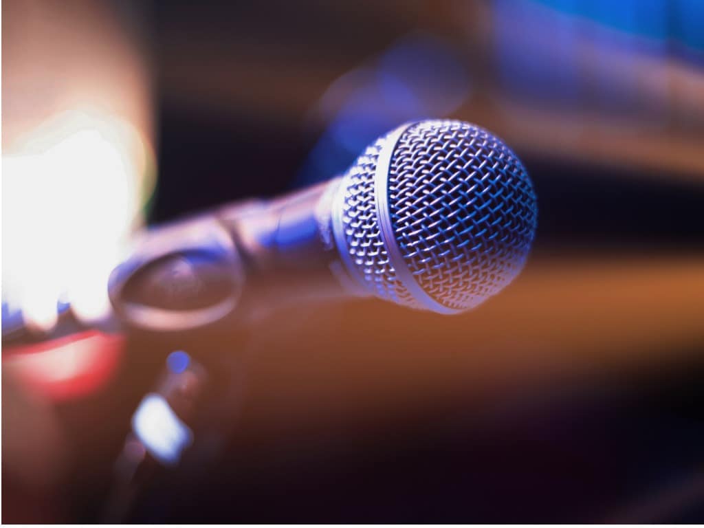 Close-up of a microphone against a dark stage background