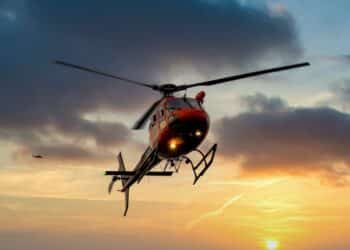 Helicopter flying in the air at sunset