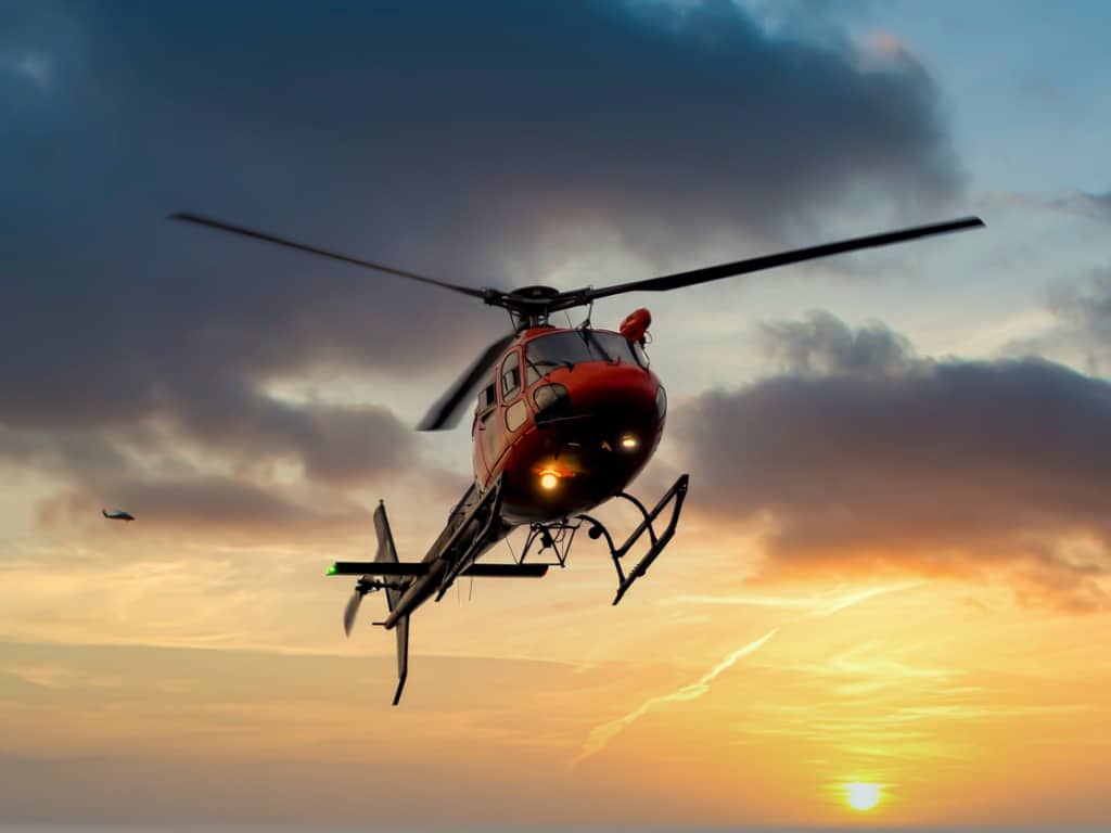 Helicopter flying in the air at sunset