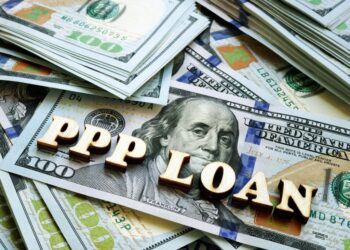 Words "PPP" loans on a pile of $100 bills