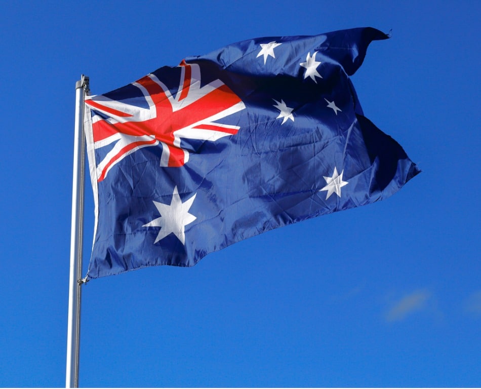 Photo of an Australian flag with blue sky behind it