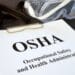 Clipboard with a paper that says "OSHA"