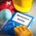 Book with the title "workplace safety" with gloves, a hard hat, and a mask surrounding it