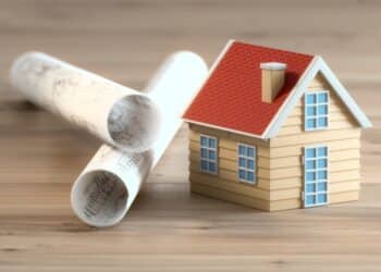 Model house with rolled-up architecture plans