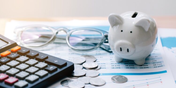 Piggy bank, calculator, and glasses on financial documents
