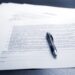 Image of a contract with a pen laying on top of it