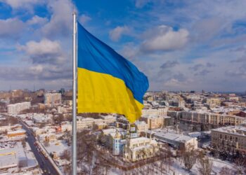 Ukrainian flag waving over a city